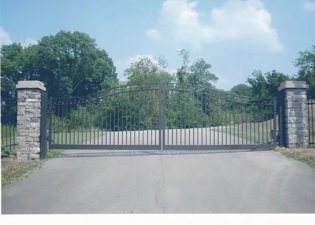 Bronze arched double swing gate on a long driveway - Elantra Gate Systems
